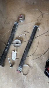 Broken garage door spring replacement service showing parts and labor cost considerations